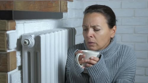 Woman Shivering and Cold Indoors Holding Mug