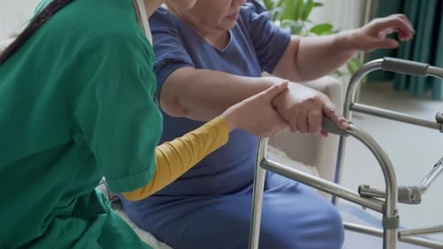Caregiver Helping Senior Woman with Walker
