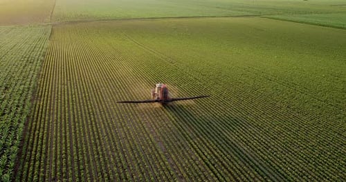 Agricultural Vehicle Spraying Crops in Rural Field