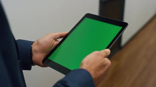Manager hands holding tablet walking office checking company data report green screen