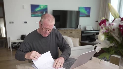 Worried Man Reviews Documents At Home