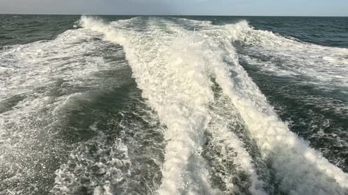 wake of water seen from behind of fast-moving motor boat in a clear sky day, Blue sea, water surface