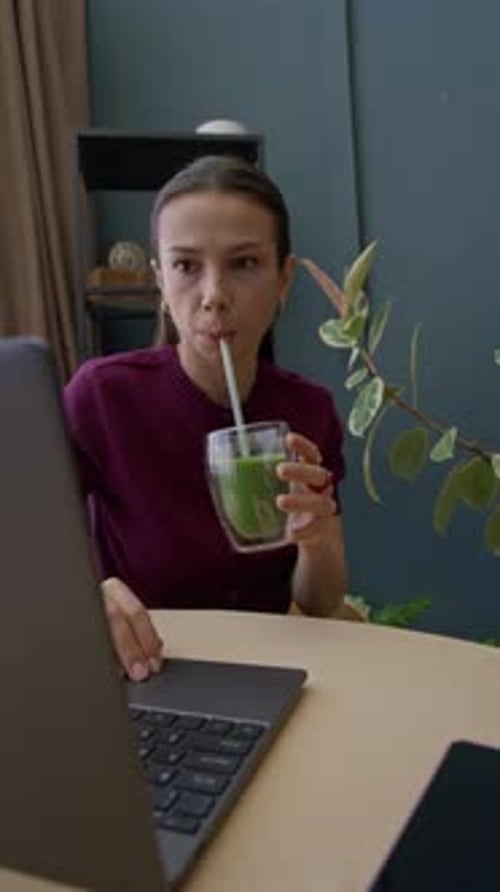 Young Woman Drinking Green Smoothie Detoxing at Home