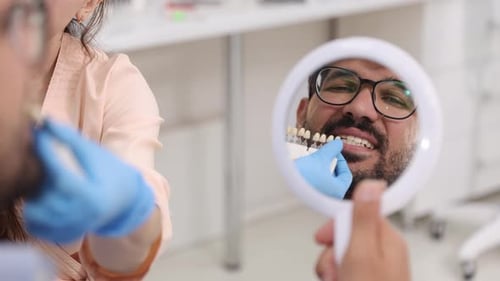 Dentist Fitting Sample Teeth to Patient in Clinic