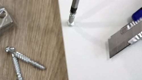 Screws Being Applied to White Surface with Drill