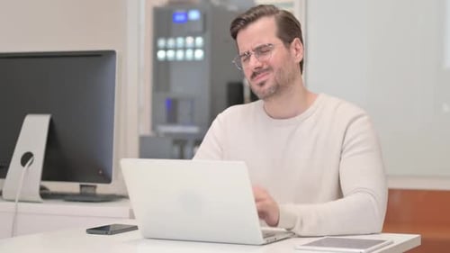 Middle Aged Man Working on Laptop in Office