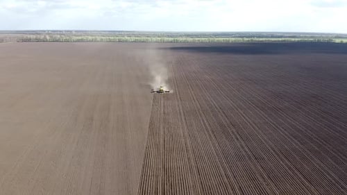 Tractor with yellow seeder working on the field in Ukraine OA Lexa