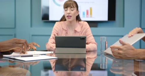 Meeting in office, woman using tablet and smiling, diverse colleagues discussing work