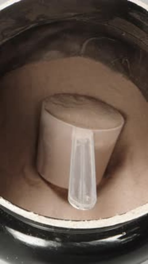 Vertical video. A black can of protein for sports nutrition, the camera flies inside