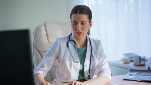 Focused Doctor Typing Keyboard Analyzing Scan Looking Xray in Medical Office