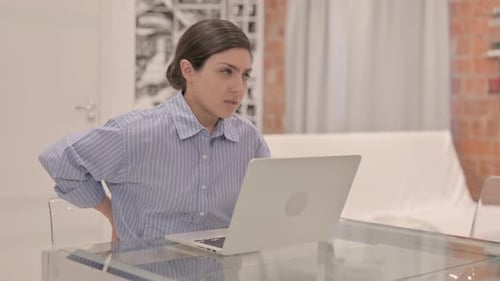 Woman Working on Laptop at Home Experiences Back Pain