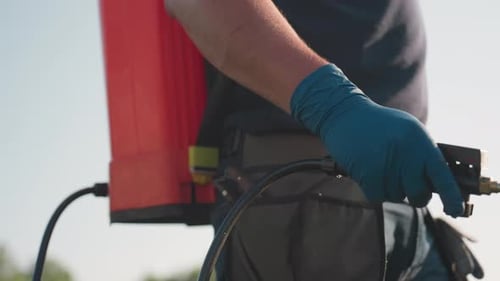 Close Up Man Fumigating with Backpack Sprayer