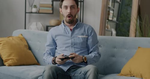 Enthusiastic Young Man Playing Video Games at Home