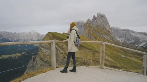 Beautiful Woman Traveler Stands on the Observation Deck in the National Park of Mountain Seceda in
