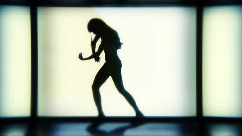 Eine Silhouette-Frau tanzt lässig vor einem hellen Bühnenhintergrund