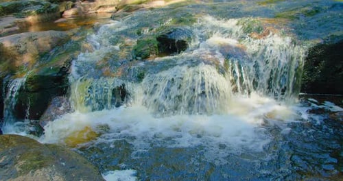 Gros plan : Mountain Fast River, courant rapide d'une cascade par une journée d'été ensoleillée