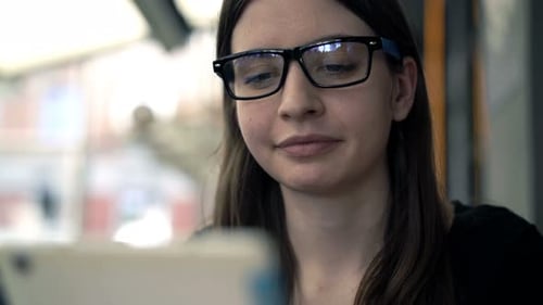 Teenage Girl Surfing Internet On Tablet Sitting In Cafe