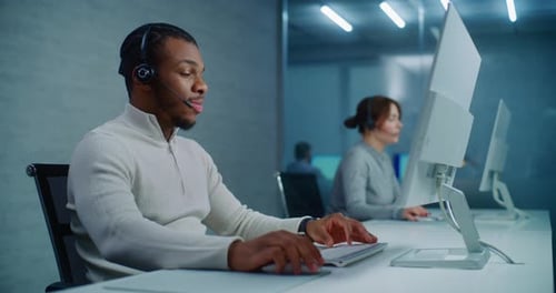 Man Working in Office at Computer with Headset