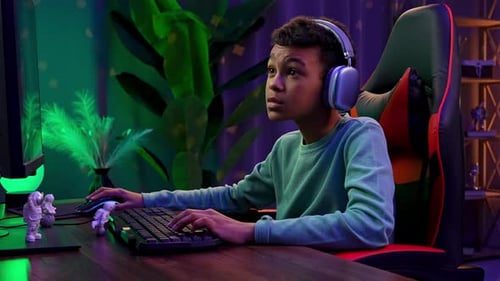 Junger afroamerikanischer Junge, der Zeit zu Hause verbringt Kid Streamer Gamer sitzt am Schreibtisch mit Computer