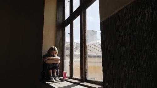 Girl Looks Very Sad While Listening Music on Headphones By the Window