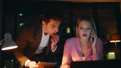 Colleagues Talking Cellphone Frustrated News in Dark Office Workplace Closeup