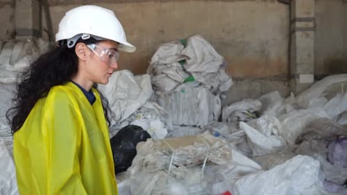 Female Inspector Walks Among Trash at Waste Sorting Plant