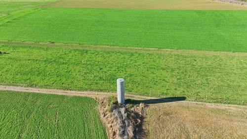 An Aerial View of An Amish Farm Water Tower and Countryside with a Rise and Center View on a Sunny F
