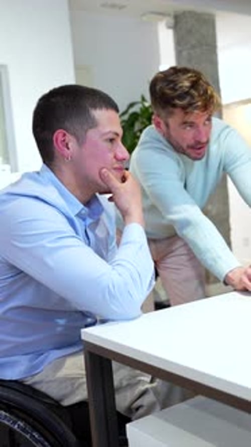 Office Workers Discussing Project One Sitting in Wheelchair