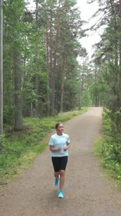 Happy Athletic Woman Running Through the Park