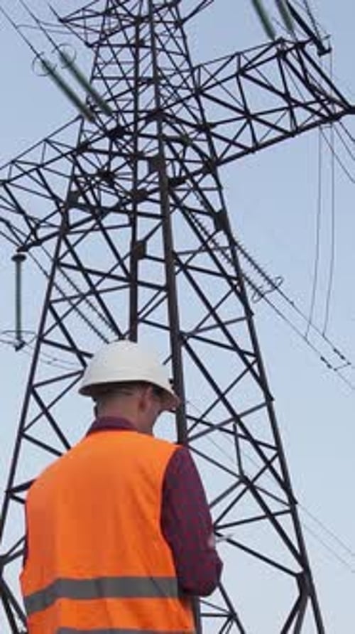 Engineer Inspecting Power Lines at Electrical Substation