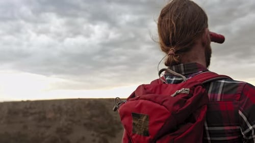 Jovem caminhando nas montanhas durante as atividades de lazer de verão com uma vista épica