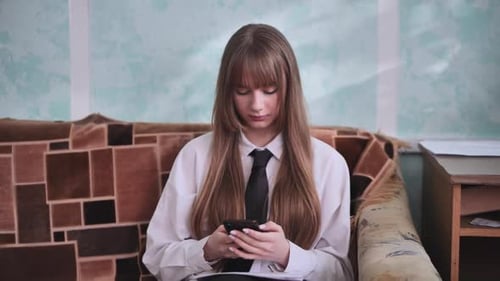 Woman Using Smartphone While Sitting on Couch