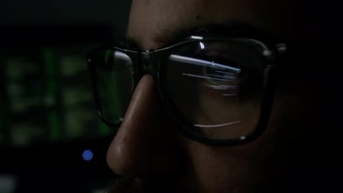 Eyes Focused on Computer Screen with Lines of Code Reflecting in Glasses