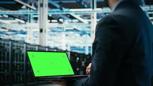 Green Screen Laptop Debugging System Errors and Technician in Data Center