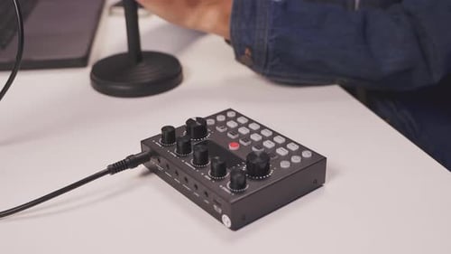 Close-up of male hands holding audio cable near sound mixer during setup