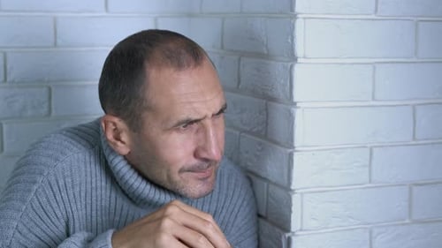 Un homme gèle dans un pull chaud à l'intérieur