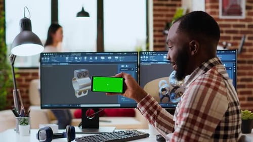 Un designer indépendant masculin travaille à distance sur des prototypes 3D à l'aide d'un écran vert