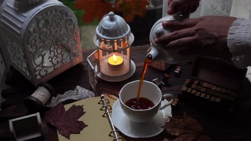 Pouring Tea at an Autumnal Decorated Table