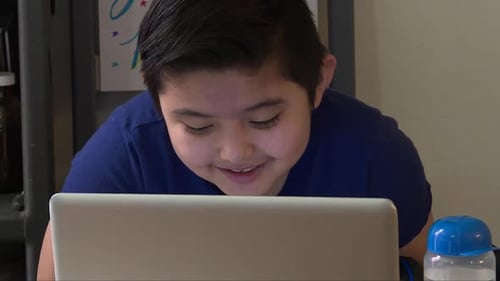 close up of kid in front of a laptop studying in the new reality after covid-19