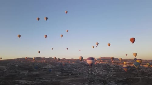 Hot Air Balloons Flying Over Cappadocia Landscape at Sunrise