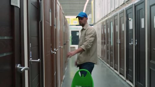 A Young Man Chooses Interroom Door in the Hardware Store