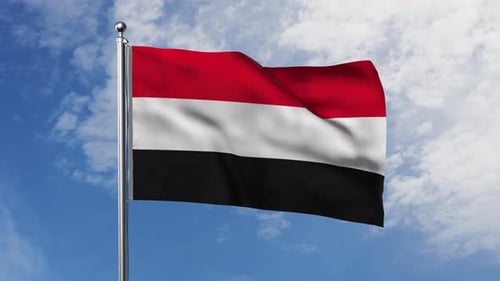 Yemen Flag Waving on Pole Against Blue Sky