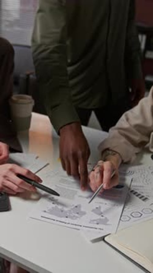 Unrecognizable Young Colleagues Working With Charts