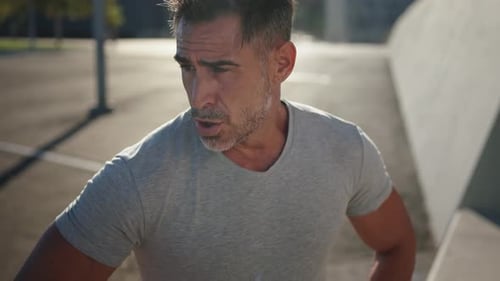 Portrait of Middle Aged Caucasian Man Resting and Taking Breath After Jogging