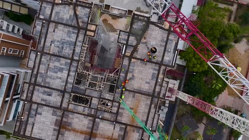 Luftbild Video Eine Baustelle eines Wolkenkratzers, auf der Arbeiter frischen Beton für den nächsten einfüllen und nivellieren