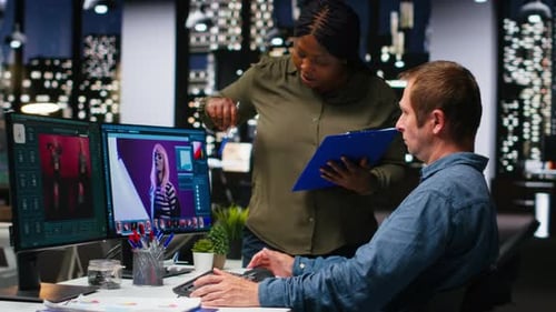 Man and Woman Discussing Photo Editing in Office