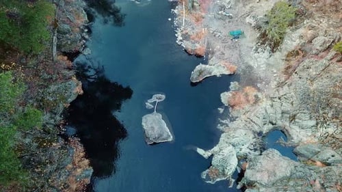 Stream Flowing In The Midst Of Mountain Forest At Daytime. - aerial tilt up