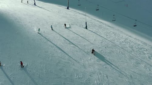 Skiers and snowboarders on beautiful winter ski slope, aerial view