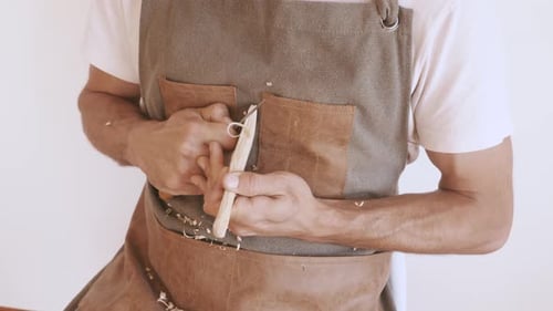 Man Carving Wood in a Home Workshop