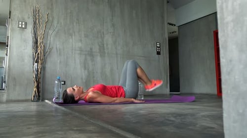 Woman Doing Leg Raises Exercise on Fitness Mat